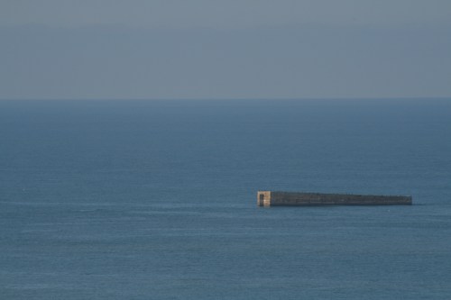 A concrete block sunk to break waves.  An artificial habour, called a mulberry, was set-up so the Allies could land equipment.  This is at Arromanchespart of Sword Beach.  The British landed here