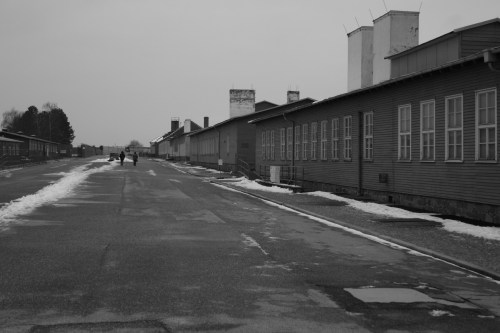 Roll call ground with the laundry facility, kitchen barrack and camp prison buildings to the right.