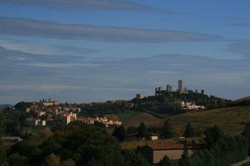 Old Town San Gimignano is to the right with all the towers.  It is surrounded by vineyards and olive trees.